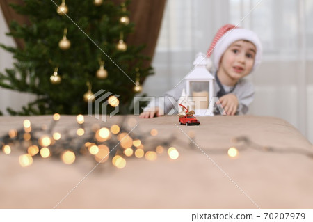 Surprised by the surprise of the child with an astonished look from a passing toy car with Christmas gifts. Surprised by the surprise of the child with an astonished look from a passing toy car with Christmas gifts. 70207979