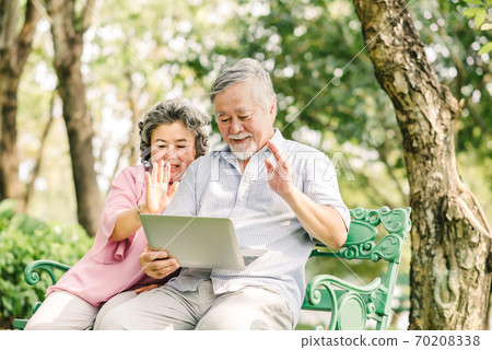 Happy senior asian couple using laptop outdoor Happy senior asian couple using laptop outdoor 70208338