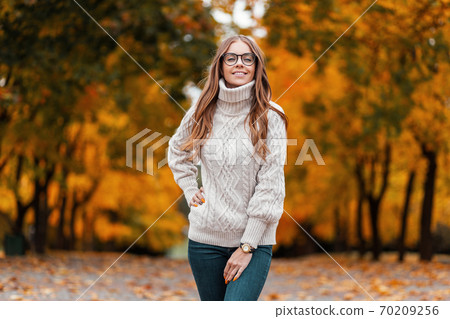 Happy young woman model in a white knitted sweater 70209256