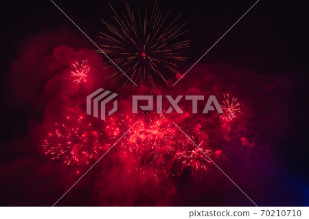 Beautiful colorful holiday fireworks in the evening sky with majestic clouds 70210710