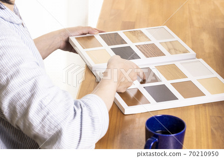 A woman looking for flooring from a sample 70210950