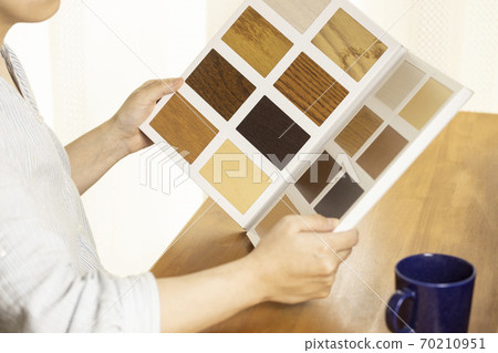 A woman looking for flooring from a sample 70210951