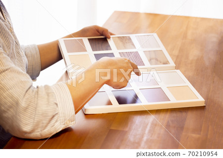 A woman looking for flooring from a sample 70210954