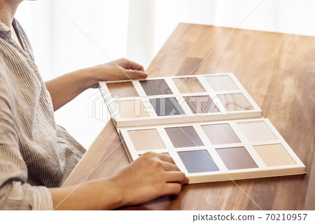 A woman looking for flooring from a sample 70210957