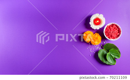 Happy Dussehra. Yellow flowers, green leaf and rice on purple pastel background. Dussehra Indian Festival concept. Happy Dussehra. Yellow flowers, green leaf and rice on purple pastel background. Dussehra Indian Festival concept. 70211109
