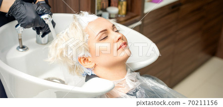 Hairdresser prepare to washes off the dye 70211156