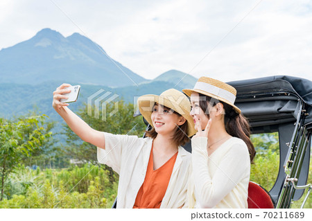 一名年輕女子和一位朋友在女孩出遊時用智能手機拍紀念照[9月] 70211689