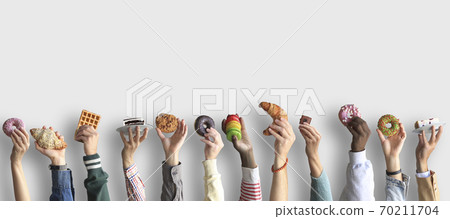 People are holding different desserts in their hands. The concept of food and sweets. People are holding different desserts in their hands. The concept of food and sweets. 70211704