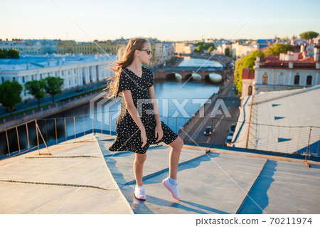 Cute girl on rooftop enjoying with view of beautiful sunset in Sankt Petersburg in Russia Cute girl on rooftop enjoying with view of beautiful sunset in Sankt Petersburg in Russia 70211974