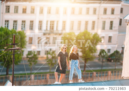 Cute girlson rooftop enjoying with view of beautiful sunset in Sankt Petersburg in Russia Cute girlson rooftop enjoying with view of beautiful sunset in Sankt Petersburg in Russia 70211983
