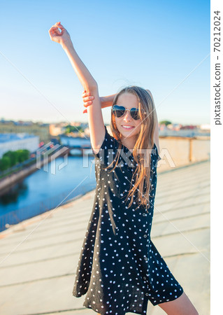 Cute girl on rooftop enjoying with view of beautiful sunset in Sankt Petersburg in Russia Cute girl on rooftop enjoying with view of beautiful sunset in Sankt Petersburg in Russia 70212024