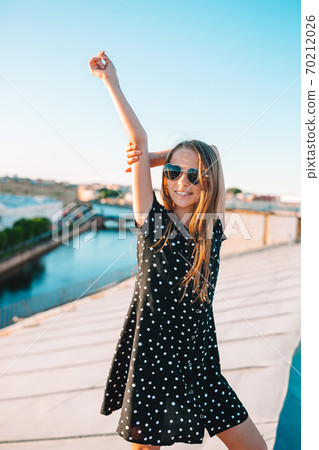 Cute girl on rooftop enjoying with view of beautiful sunset in Sankt Petersburg in Russia Cute girl on rooftop enjoying with view of beautiful sunset in Sankt Petersburg in Russia 70212026