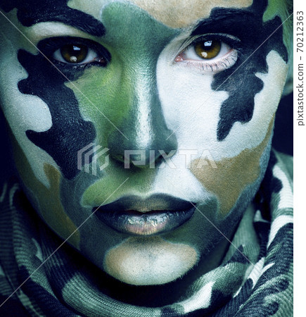 Beautiful young fashion woman with military style clothing and face paint make-up, khaki colors, halloween celebration Beautiful young fashion woman with military style clothing and face paint make-up, khaki colors, halloween celebration 70212363