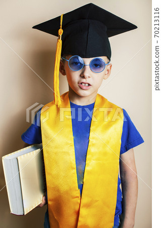 little cute preschooler boy in glasses with books at home education in graduate hat smiling posing emotional, lifestyle people concept little cute preschooler boy in glasses with books at home education in graduate hat smiling posing emotional, lifestyle people concept 70213116
