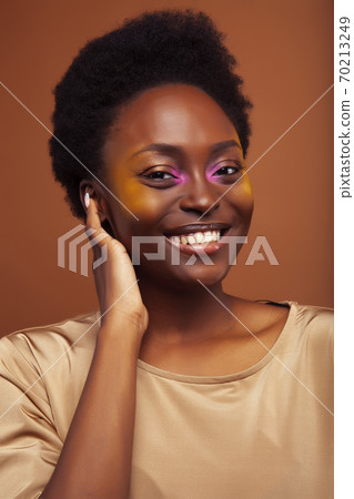 pretty young african american woman with curly hair posing cheerful gesturing on brown background, lifestyle people concept pretty young african american woman with curly hair posing cheerful gesturing on brown background, lifestyle people concept 70213249