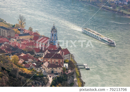 Duernstein village with castle against tourist boat on Danube river during autumn, Wachau in Austria 70213706