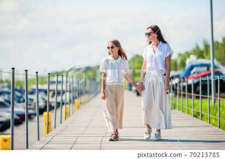 Young mother and little girl in port at summer day 70213785