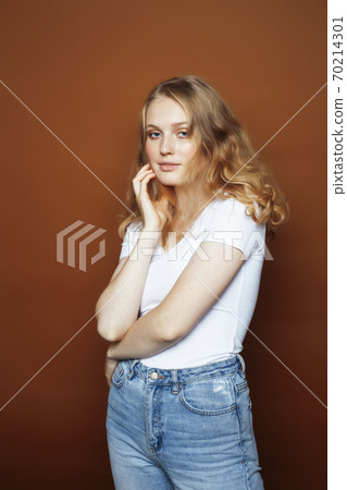 young pretty girl with blond hair posing cheerful on brown background, lifestyle people concept 70214301
