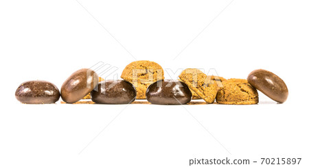 Pepernoten in a bunch of traditional and chocolate treats in a row on white background Pepernoten in a bunch of traditional and chocolate treats in a row on white background 70215897