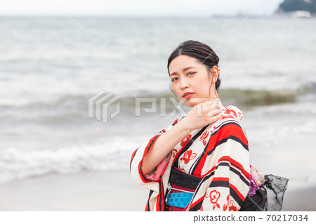 A woman in a yukata standing on the beach 70217034