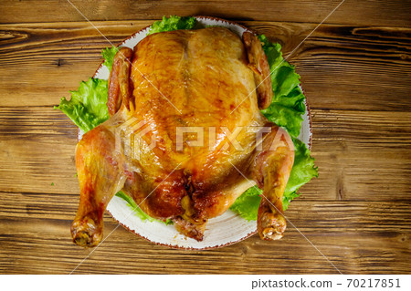Baked whole chicken on a wooden table. Top view Baked whole chicken on a wooden table. Top view 70217851