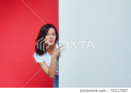 beautiful girl gestures to an empty space for the text. Presentation of your product. 70217967