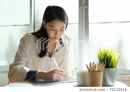 Young collage student using computer and mobile device studying online. 70218016