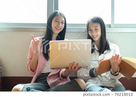 Young students campus helps friend catching up and learning. 70218018