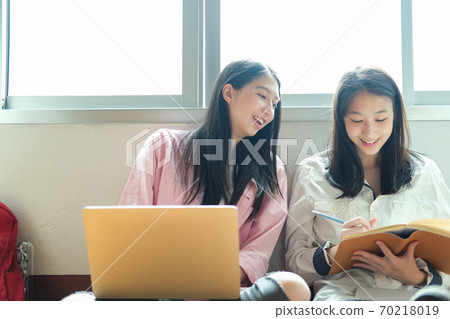 Young students campus helps friend catching up and learning. 70218019