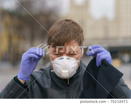Man wearing protective mask outdoors. Coronavirus pandemic time. Man wearing protective mask outdoors. Coronavirus pandemic time. 70218471