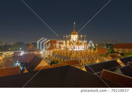 Loha Prasat Wat Ratchanatda and Golden Mountain pagoda, a buddhist temple or Wat Saket with skyscraper buildings in Bangkok Downtown, urban city, Thailand. Thai Landmark. Architecture at night. 70218637