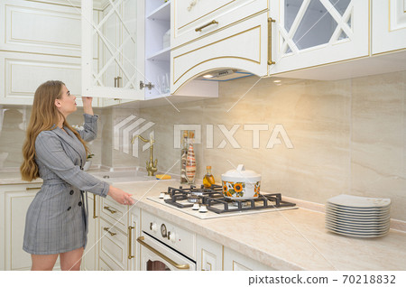 Young beautuful woman at beige kitchen Young beautuful woman at beige kitchen 70218832