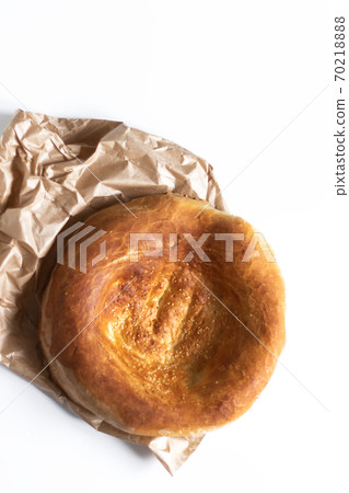 Lavash on a white table. Traditional Asian cuisine. Yeast-free baked goods. Waste-free paper packaging Lavash on a white table. Traditional Asian cuisine. Yeast-free baked goods. Waste-free paper packaging 70218888