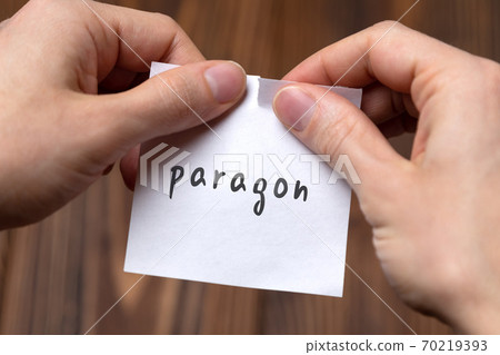 Hands tearing off paper with inscription paragon Hands tearing off paper with inscription paragon 70219393