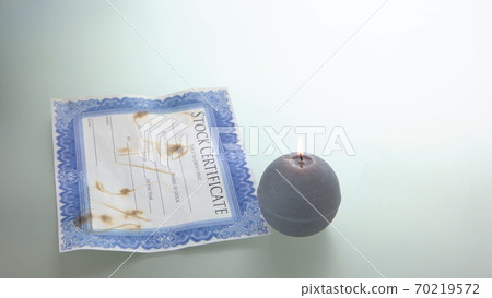 Stock certificate and burning candle. Stock certificate and burning candle. 70219572