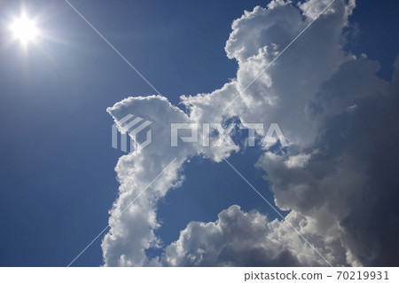 White clouds in the blue sky against the bright sun White clouds in the blue sky against the bright sun 70219931