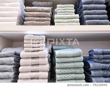 Terry towels of various colors are folded neatly on the shelves. Concept for lifestyle, retail, comfort. 70220443