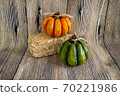 Decorative green and orange pumpkin and a hey stack isolated on the wood background. Holidays 70221986