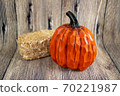 Colorful pumpkin and a hey stack isolated on the wood background. Thanksgiving content 70221987