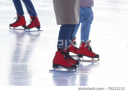 feet of different people skating on the ice rink 70222212