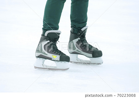 Legs of a man skating on an ice rink. Hobbies and sports. Vacations and winter activities. Legs of a man skating on an ice rink. Hobbies and sports. Vacations and winter activities. 70223008