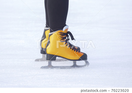legs of a girl ice skating on an ice rink. Hobbies and sports. Vacations and winter activities. legs of a girl ice skating on an ice rink. Hobbies and sports. Vacations and winter activities. 70223020