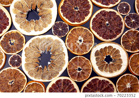 Dried of various citrus fruits closeup on dark background Dried of various citrus fruits closeup on dark background 70223352