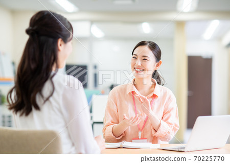 A casual business woman who consults with a young woman in the office A casual business woman who consults with a young woman in the office 70225770