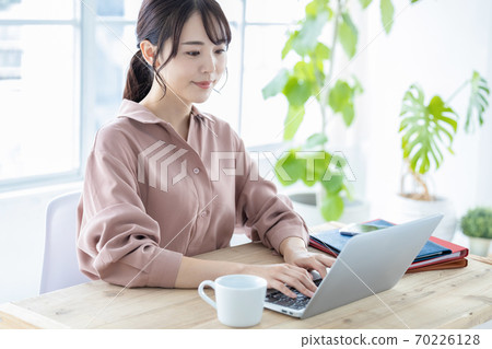 Telework A young woman looking at a personal computer 70226128