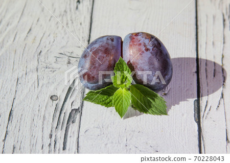 Trendy ugly organic fruit purple plum on the wooden background. Trendy ugly organic fruit purple plum on the wooden background. 70228043