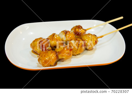 Grilled meatballs or pork on skewers with chili sauce in white plate, focus selective 70228307