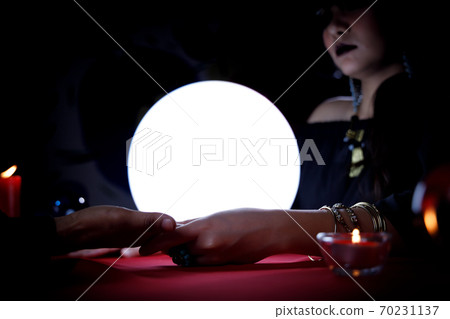 Fortune teller reading customer's palm to forecast future or fate. Fortune teller reading customer's palm to forecast future or fate. 70231137