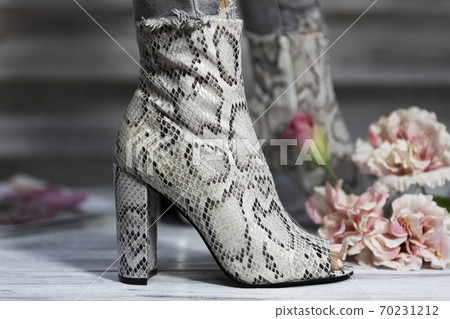 Luxury female high heel shoes made from snake skin worn by a woman Luxury female high heel shoes made from snake skin worn by a woman 70231212