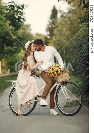 Couple with vintage bicycle in the summer park Couple with vintage bicycle in the summer park 70232921